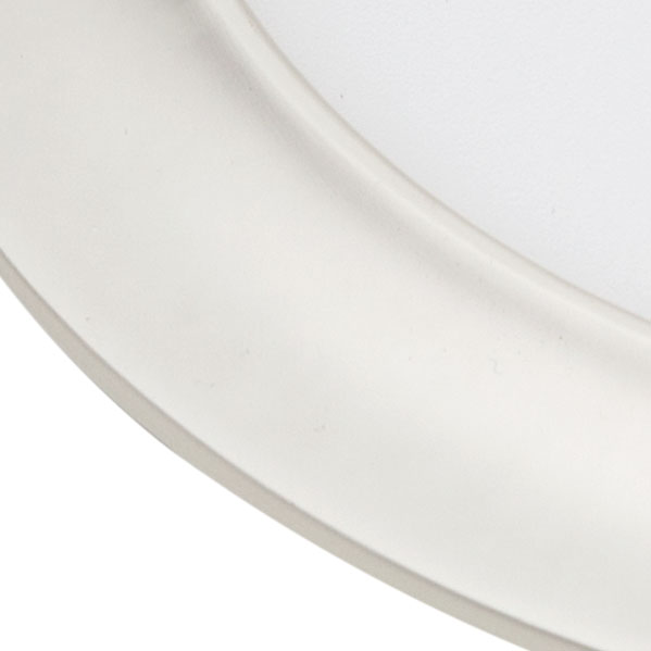 Primer plano del borde curvo de un plato de cerámica blanca sobre un fondo liso.