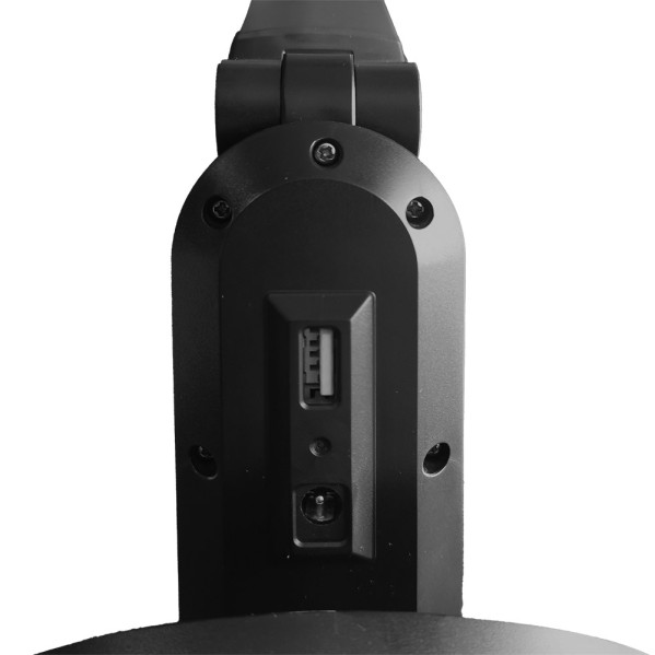 Pieza de plástico negro con puerto USB y tornillos sobre fondo claro.