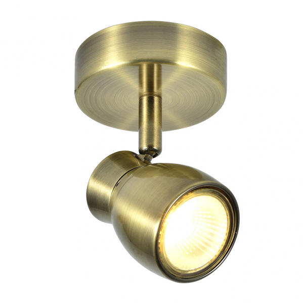 Un foco de techo de latón antiguo con cabezal ajustable que emite luz cálida.