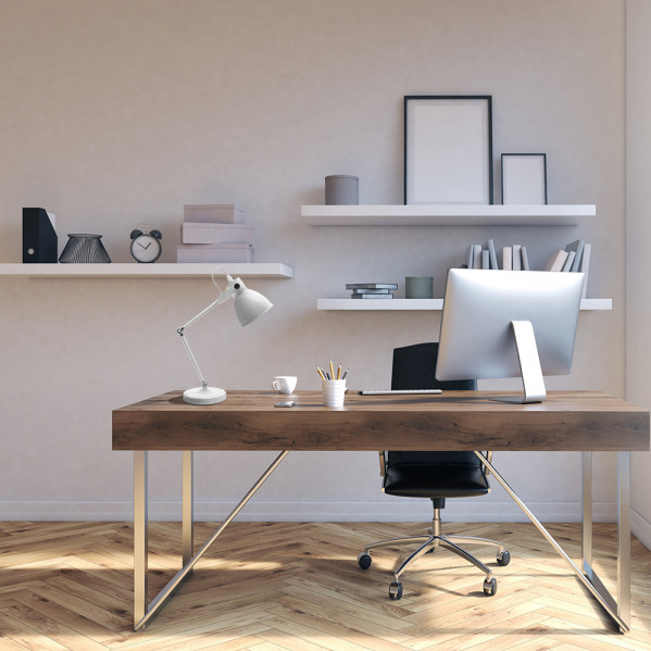 Escritorio moderno con ordenador, lámpara y silla en una oficina luminosa.