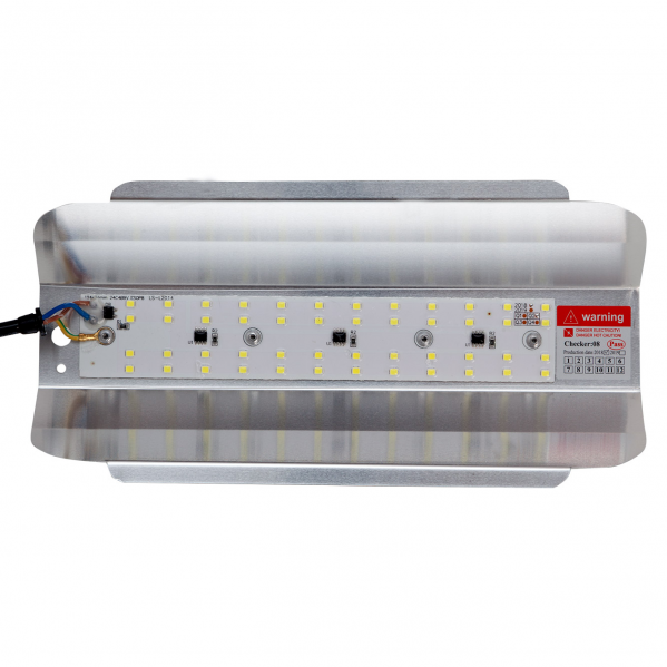 Un módulo de luz LED con reflector de metal plateado, múltiples diodos amarillos y etiqueta de advertencia.