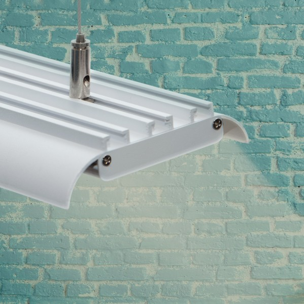 Una lámpara blanca cuelga frente a una pared de ladrillos azules.