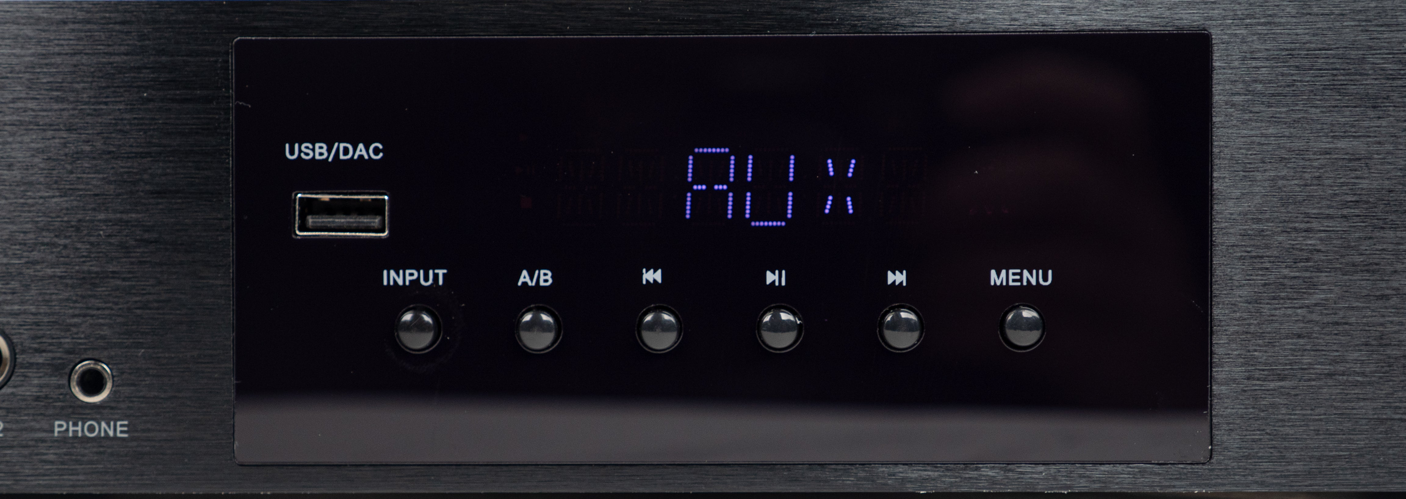 Schwarzes Audio-Gerät mit digitaler Anzeige, die AUX zeigt, USB-Anschluss und runden Tasten darunter.