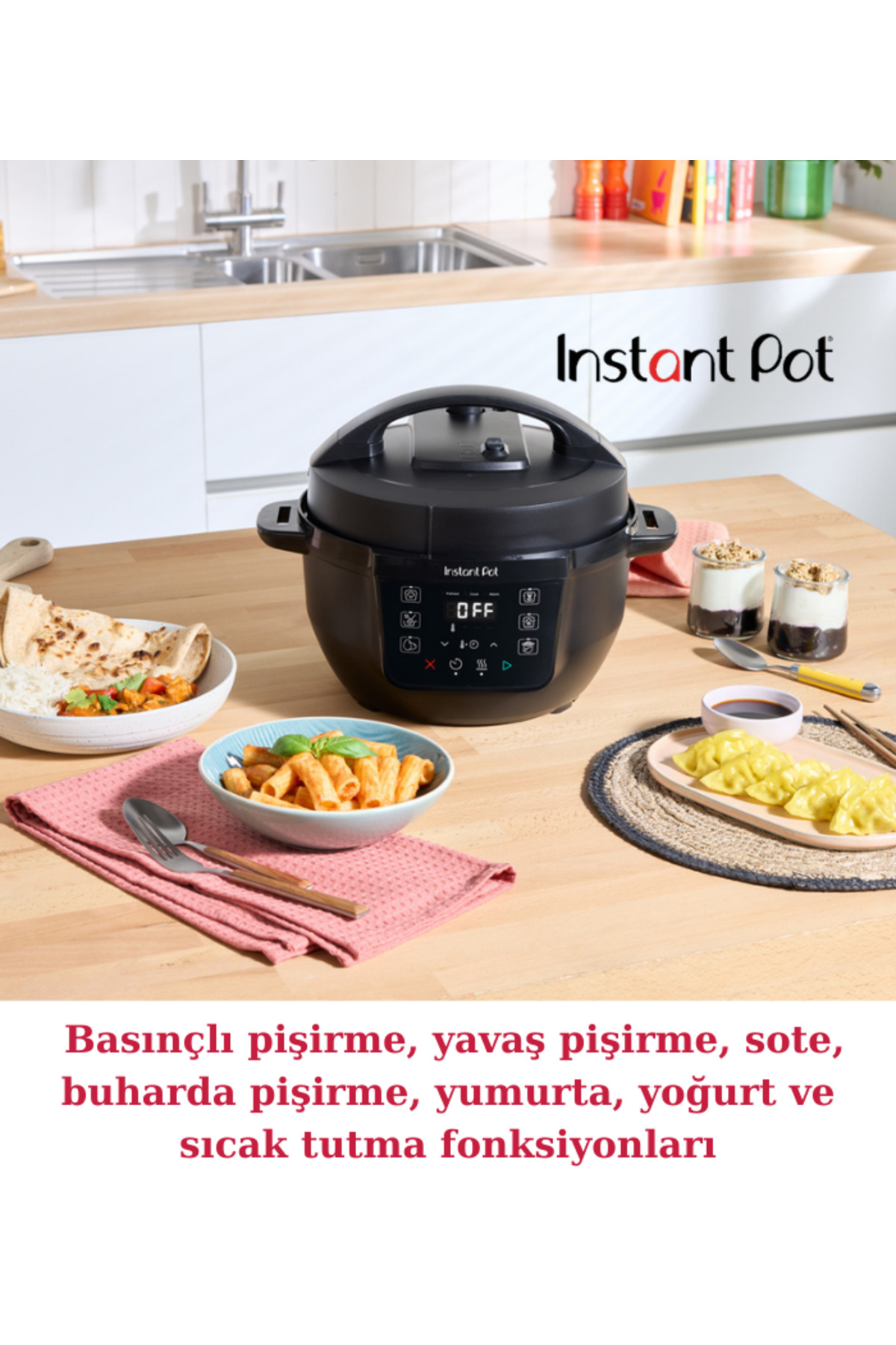 Czarny Instant Pot stoi na drewnianym stole z różnymi potrawami, takimi jak makaron, chleb i pierożki.