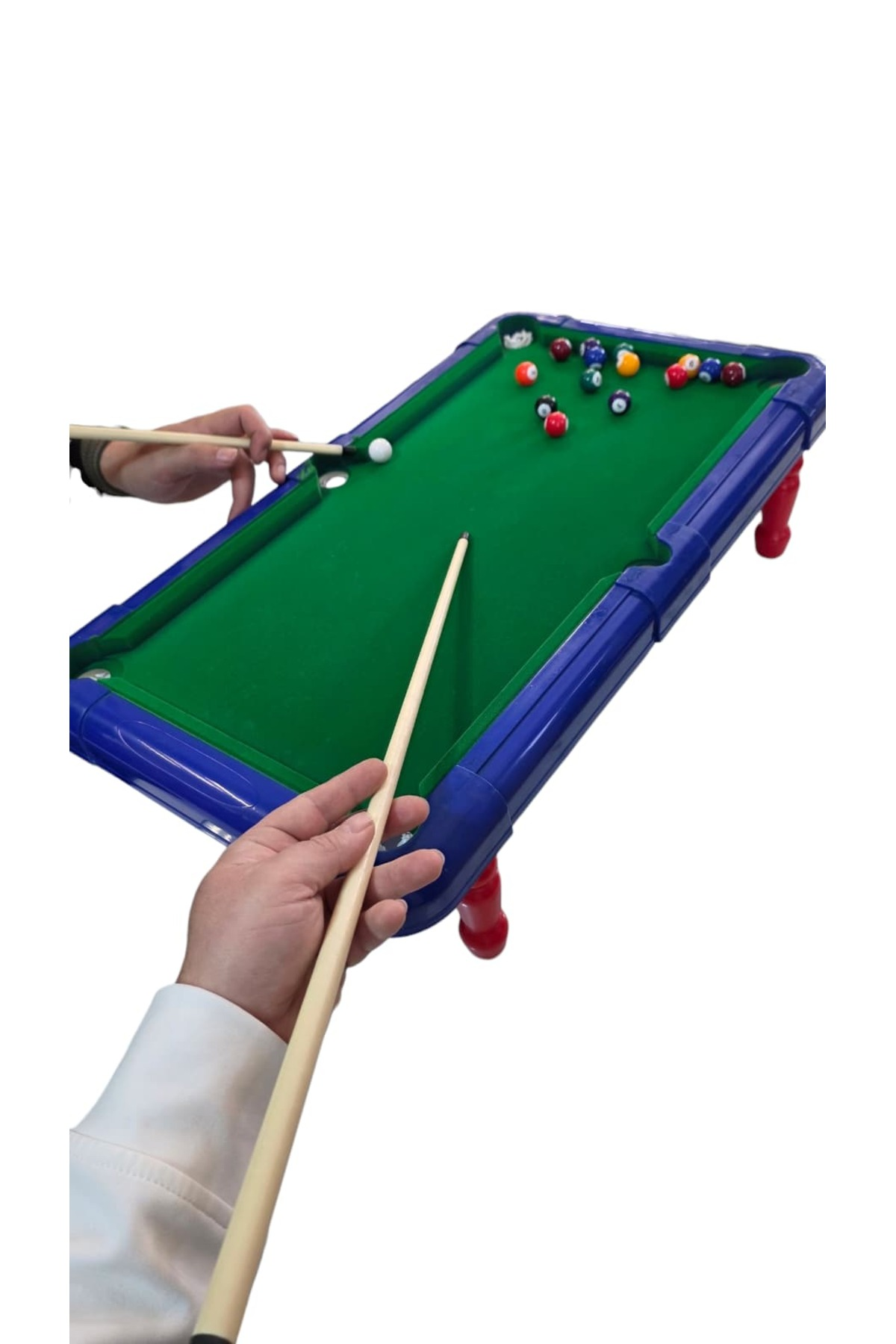 Mavi çerçeveli ve kırmızı ayaklı küçük yeşil bilardo masasında oynayan insanlar.