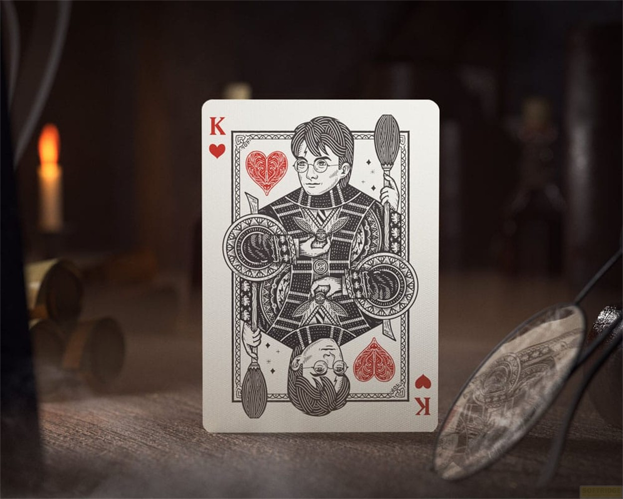 Une carte à jouer style Harry Potter montre le Roi de Cœur en noir, blanc et rouge sur fond en bois.