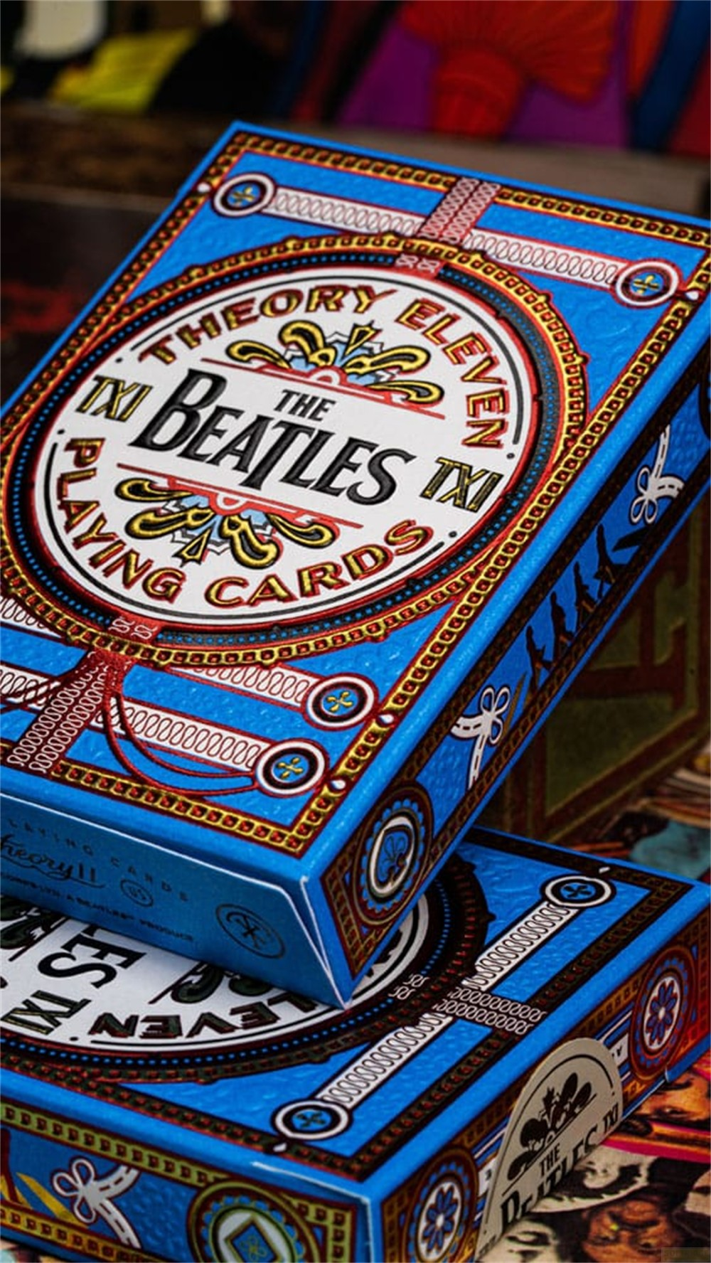 Boîte de cartes à jouer bleue The Beatles de Theory Eleven avec des motifs dorés et blancs complexes.