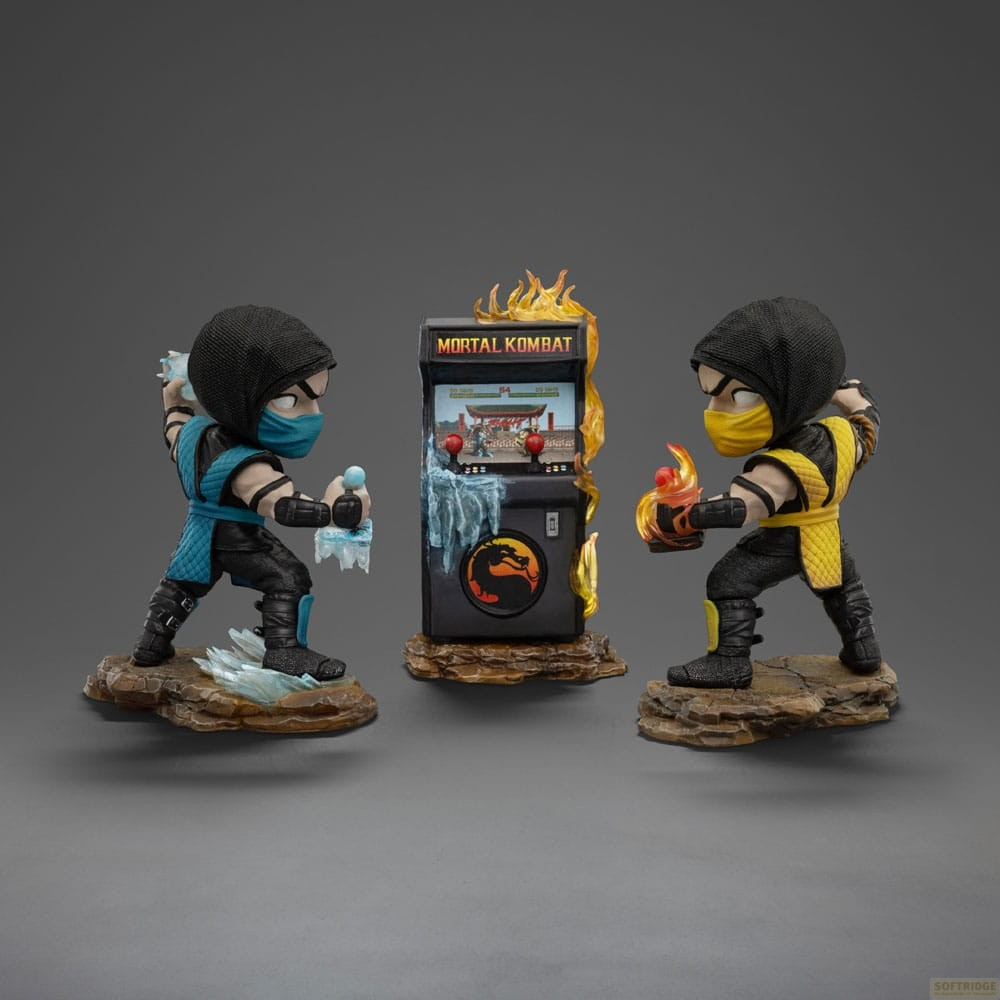 Dos figuras de acción de Mortal Kombat, Sub-Zero y Scorpion, frente a una máquina arcade.