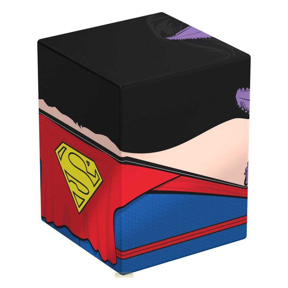 Un cube noir à l'effigie de Superman, une cape rouge avec un logo jaune et une armure bleue sur fond blanc.