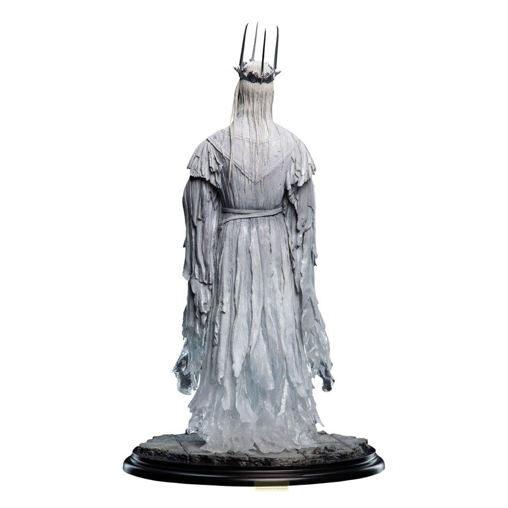 Vista trasera de una figura de rey fantasmal blanco con corona y túnicas fluidas sobre base de piedra.