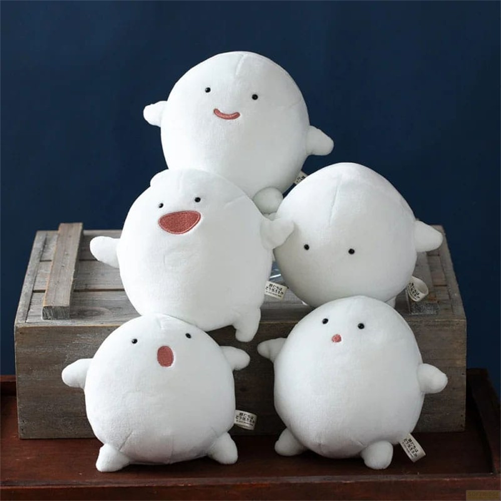 Cinco peluches blancos y redondos con diferentes expresiones faciales sobre una caja de madera.