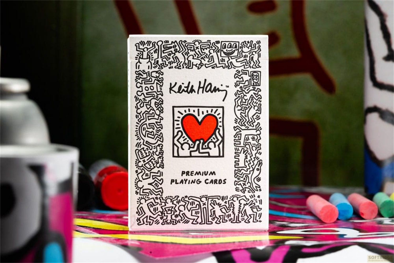 Boîte de cartes Keith Haring avec cœur rouge et dessins sur une table colorée.