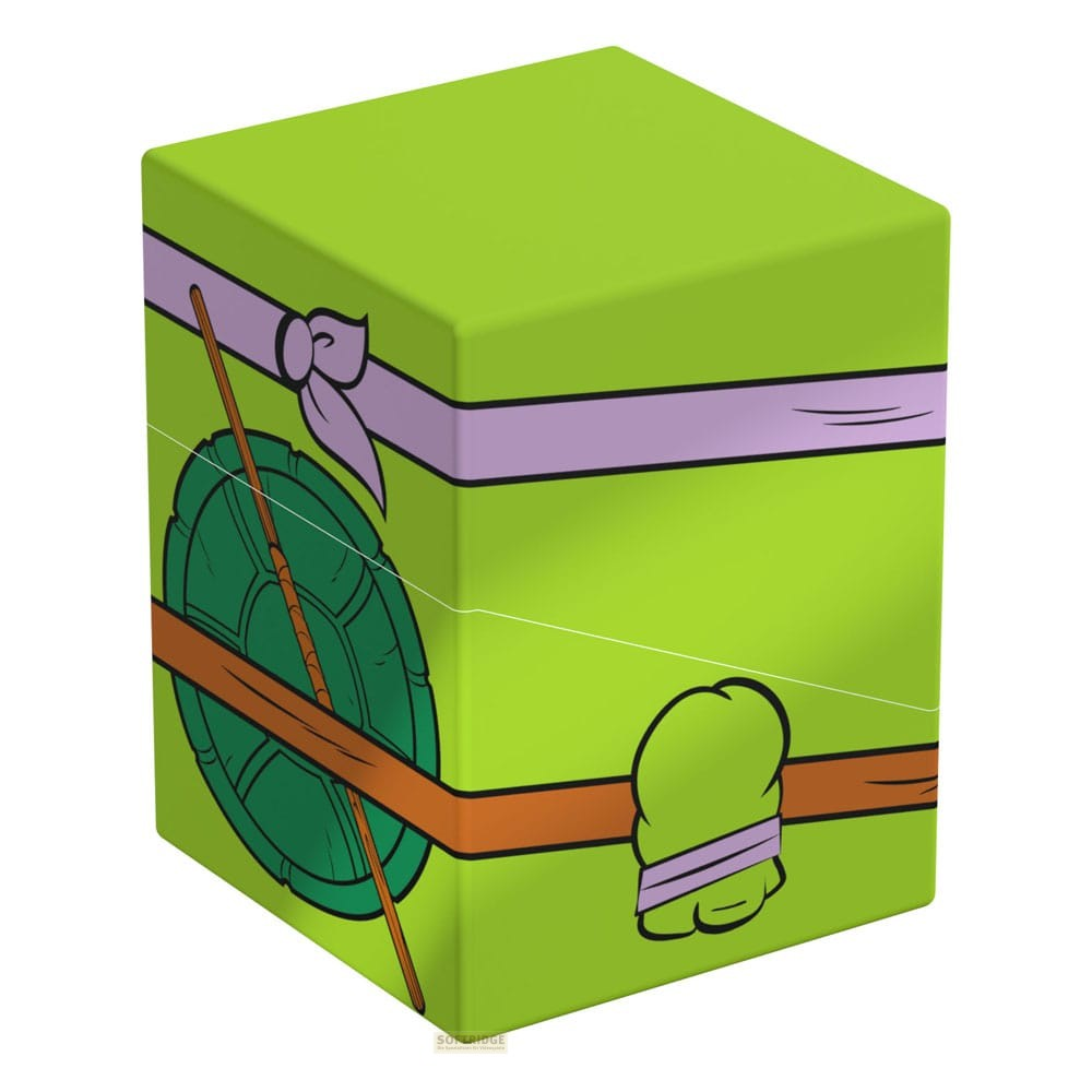 Boîte verte avec un ruban violet, une ceinture marron et une carapace inspirée des Tortues Ninja.