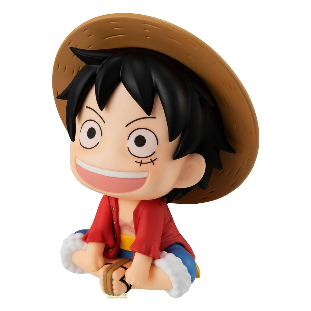 Una pequeña figura de Monkey D. Luffy con sombrero de paja, camisa roja y una gran sonrisa está sentada.