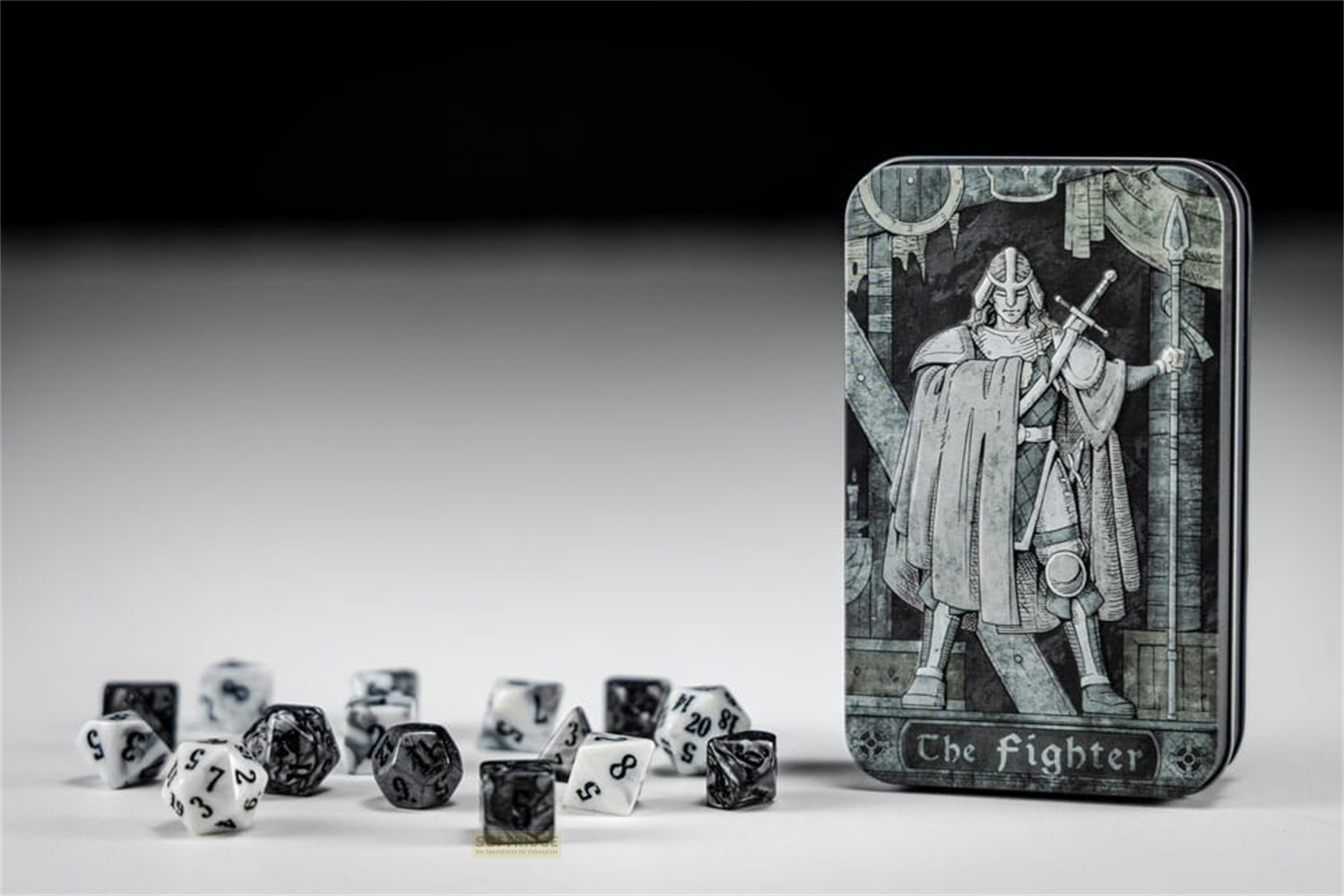 Une boîte en métal avec une illustration de guerrier et des dés noirs et blancs.