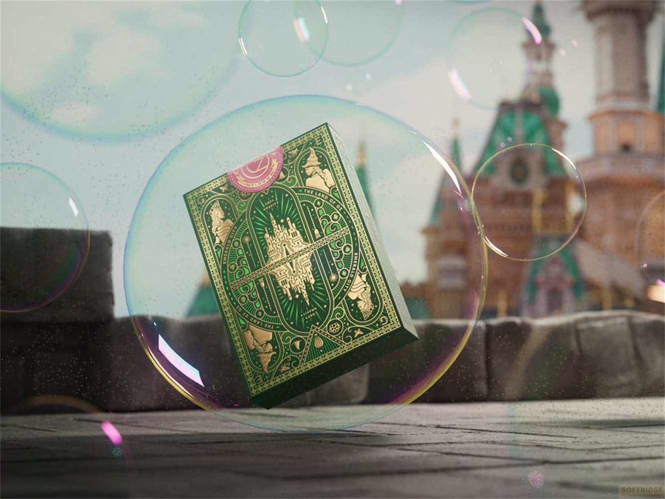 Un étui de cartes vert avec des motifs dorés flotte dans une bulle, devant un château et d'autres bulles.