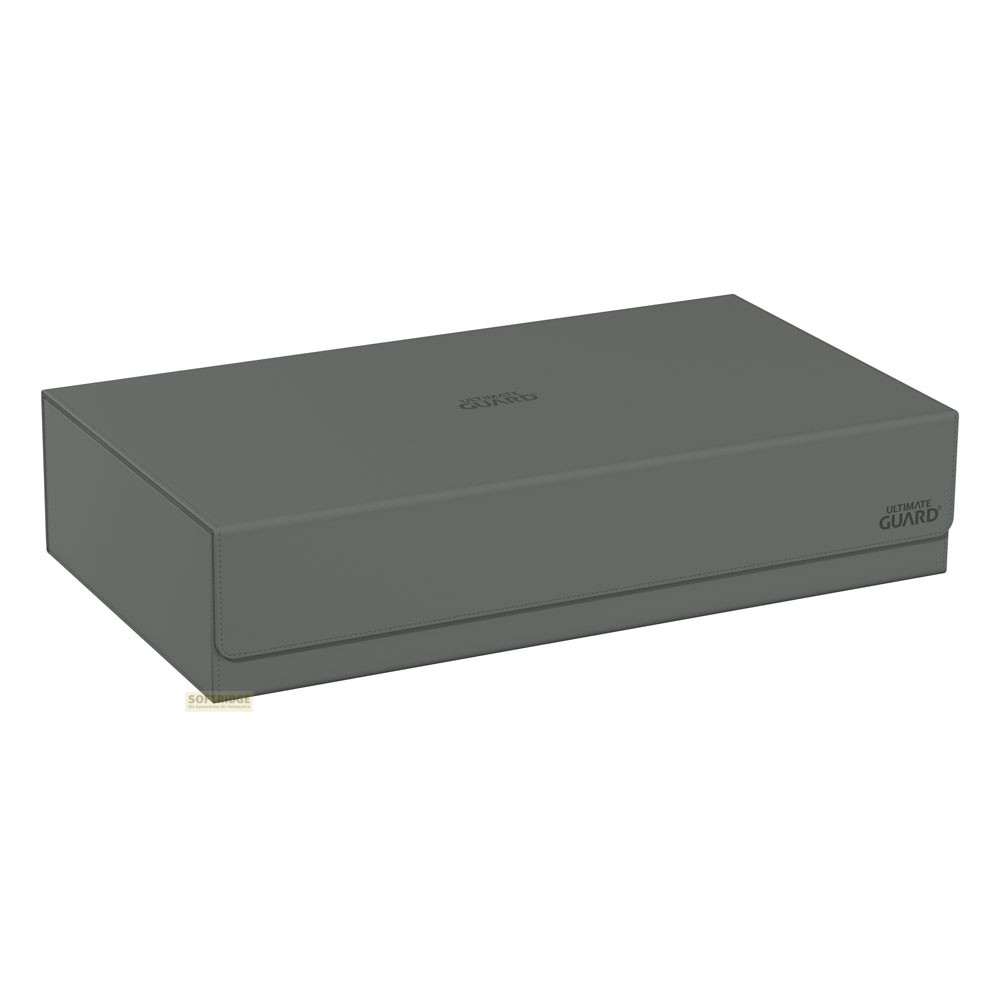 Une boîte de rangement grise Ultimate Guard avec logo sur fond blanc.