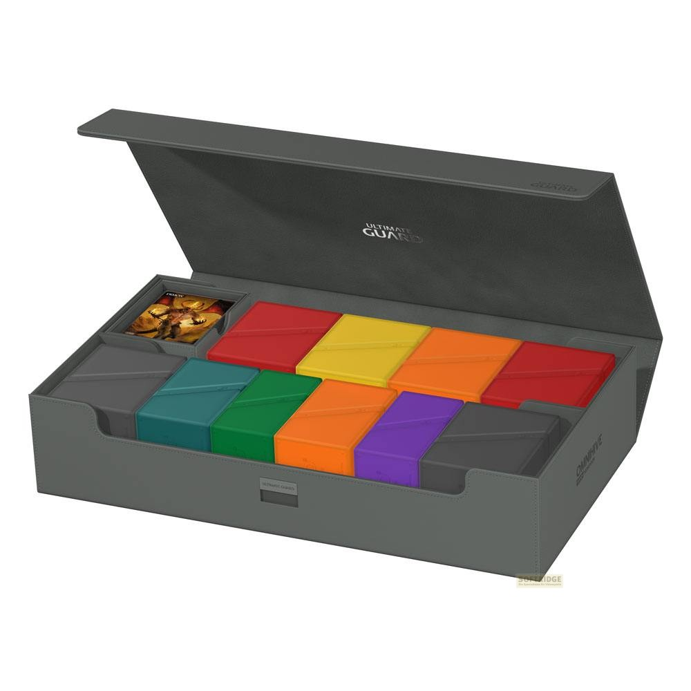 Une boîte de rangement grise ouverte remplie de petites boîtes colorées pour cartes à collectionner.