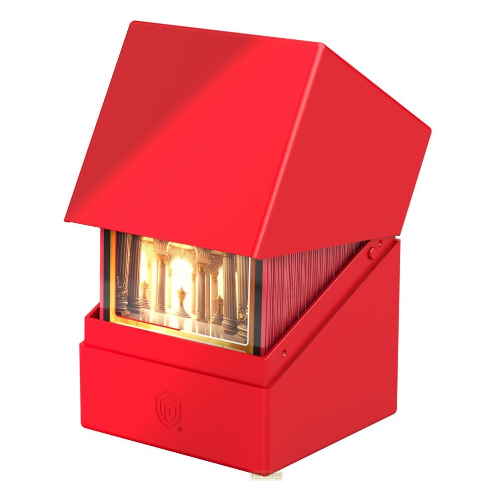 Une boîte de deck rouge avec couvercle ouvert révèle des cartes à collectionner et une scène de temple ancien.