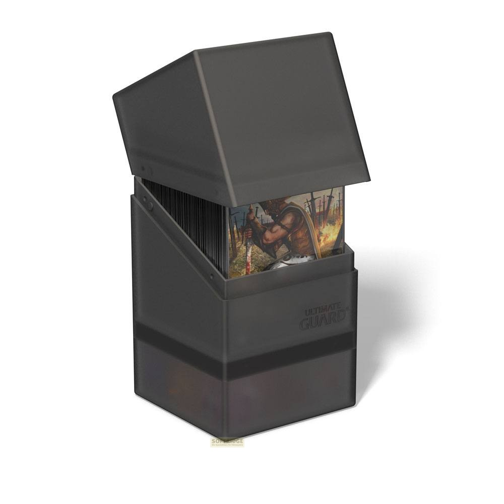Boîte de cartes Ultimate Guard grise avec couvercle ouvert, révélant un deck de cartes sur fond blanc.