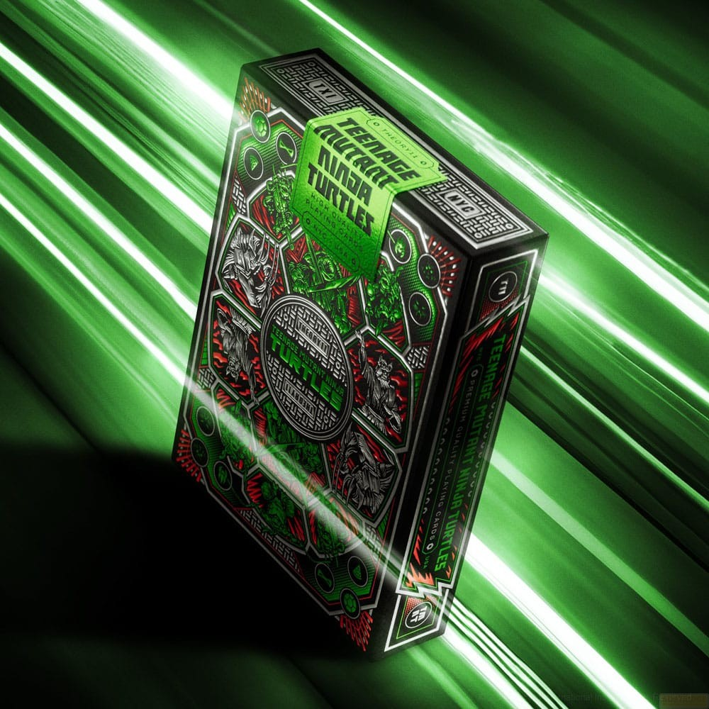 Une boîte de cartes à jouer Ninja Turtles verte et détaillée sur fond vert avec des stries de lumière.
