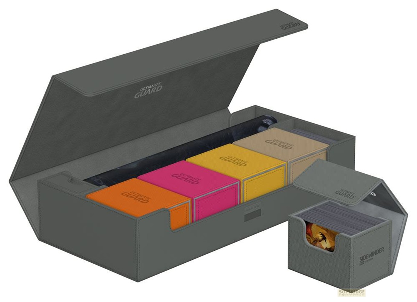Une grande boîte grise contient quatre boîtes de deck colorées et un tapis, plus une boîte à côté.