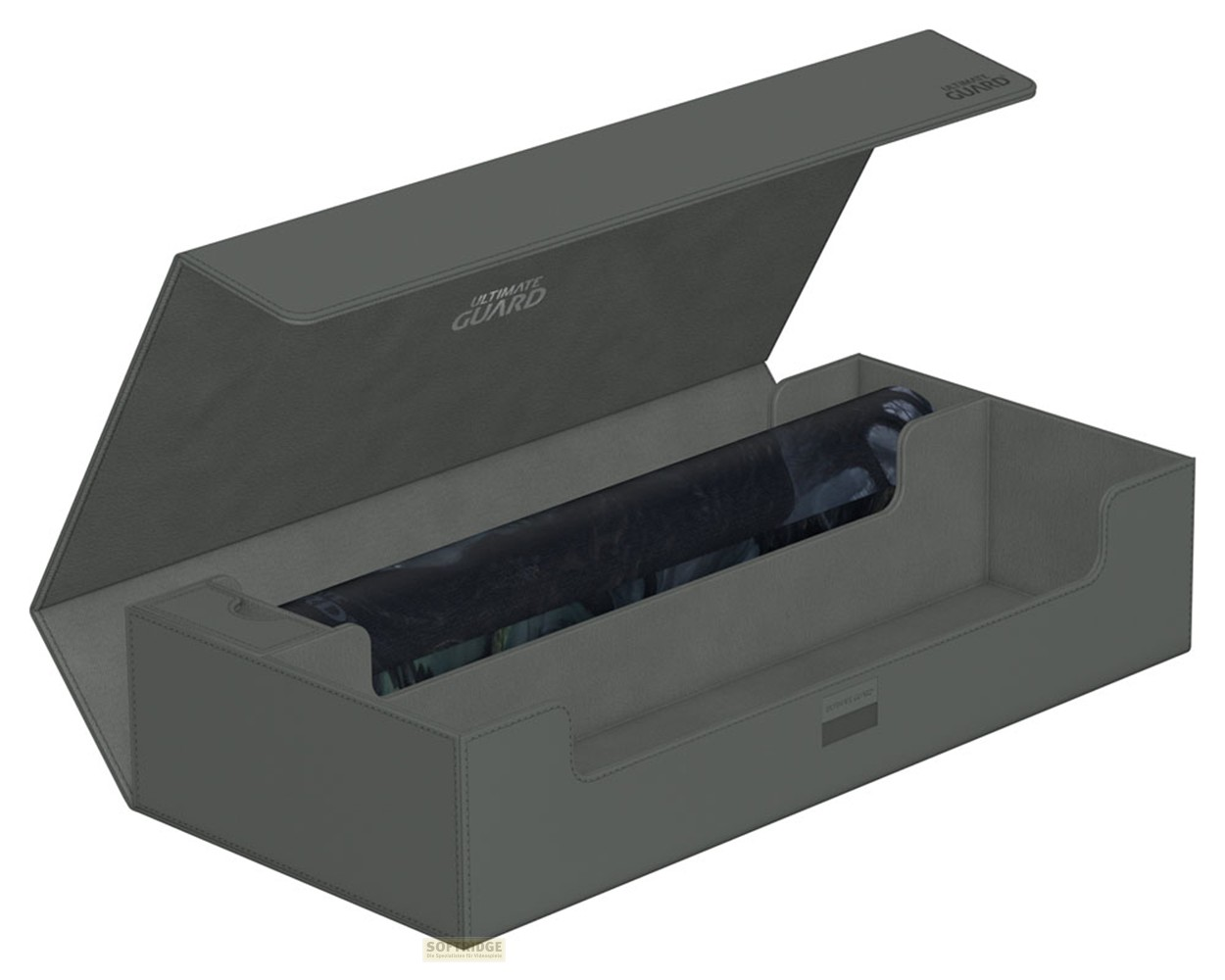 Une boîte de cartes grise Ultimate Guard avec un couvercle ouvert et un tapis de jeu enroulé à l'intérieur.