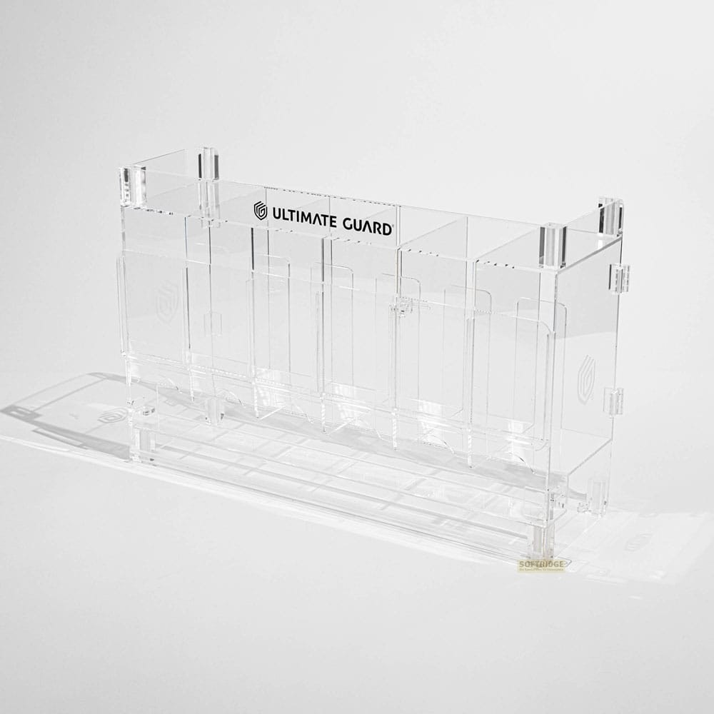 Une boîte de rangement de cartes en acrylique transparent Ultimate Guard vide sur fond blanc.