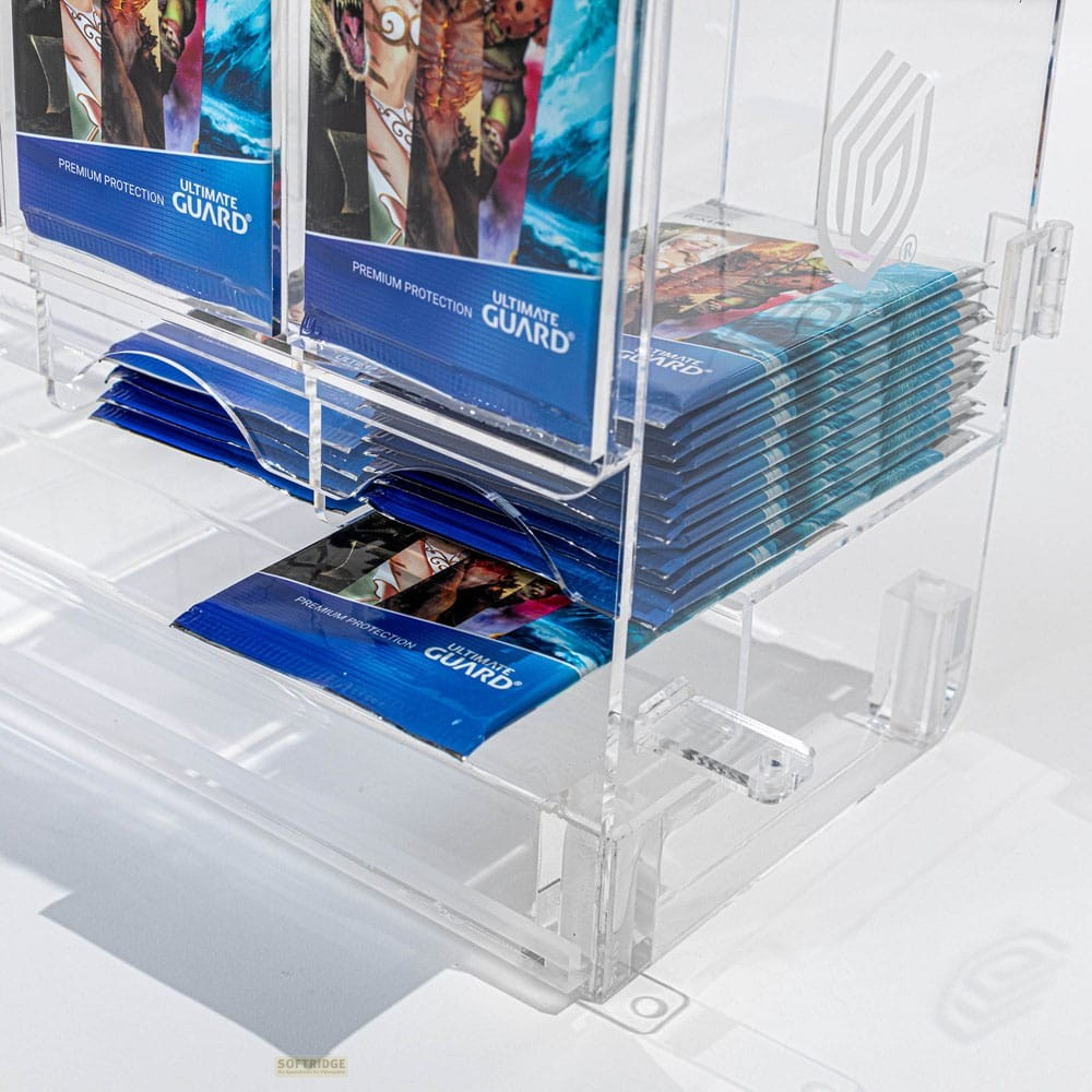 Présentoir en acrylique transparent rempli de paquets de cartes Ultimate Guard empilés.