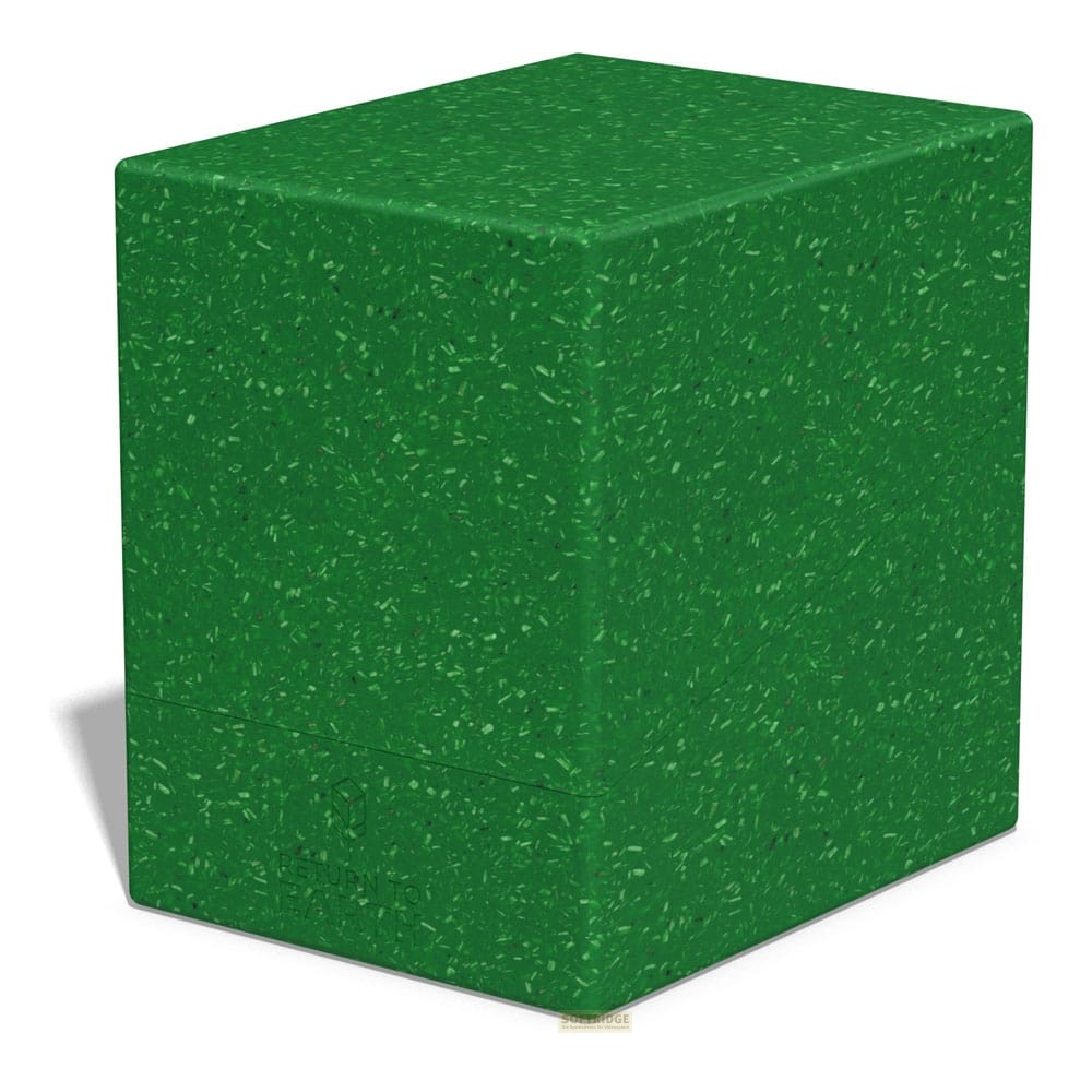Un bloc vert moucheté repose sur une surface blanche, projetant une douce ombre à gauche.