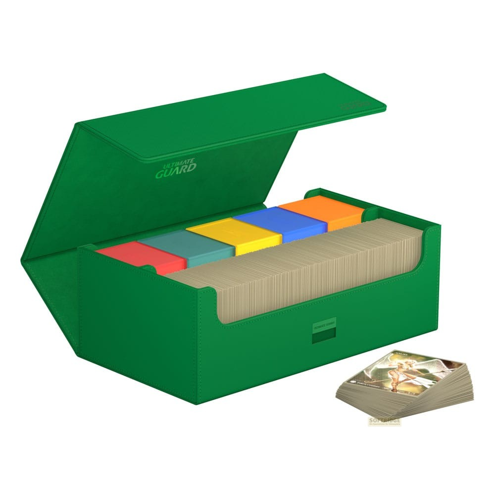 Boîte de deck verte ouverte remplie de cartes et de petites boîtes colorées, avec une petite pile de cartes à côté.