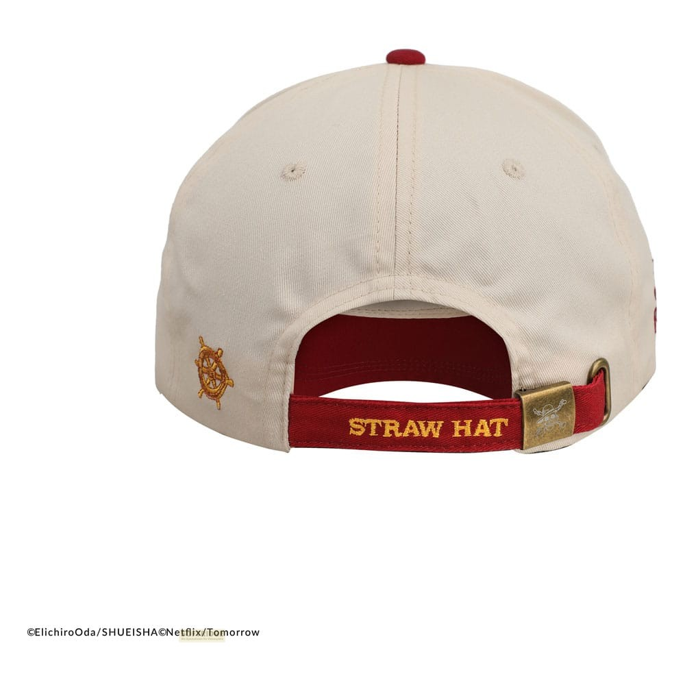 Gorra beis vista desde atrás, con correa roja, texto STRAW HAT y bordado de timón dorado.
