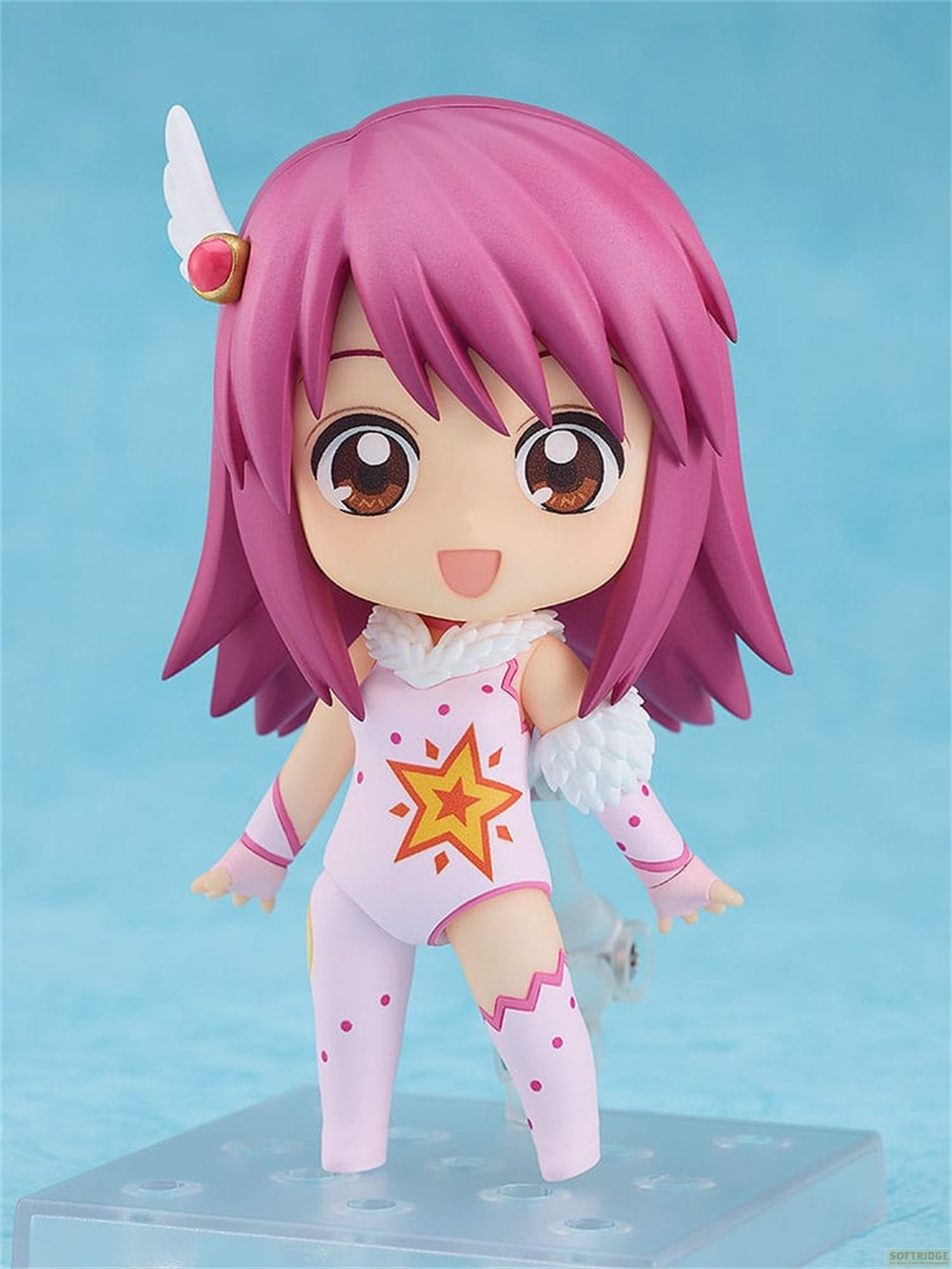 Una figura de anime de pelo rosado con un traje de estrellas sobre una base.