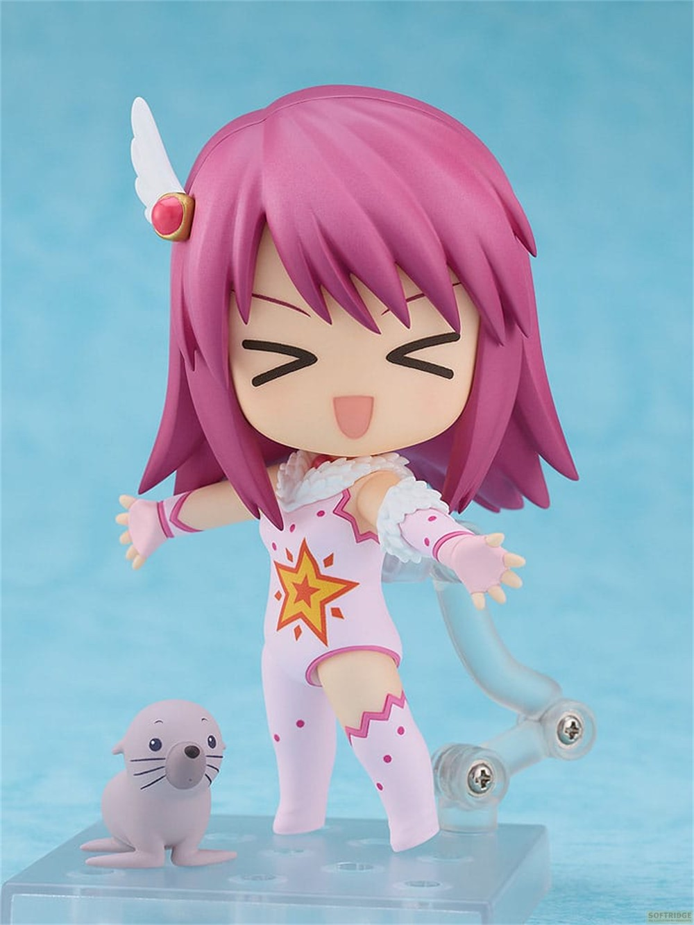Una figura de anime rosa con una estrella y foca en un soporte.