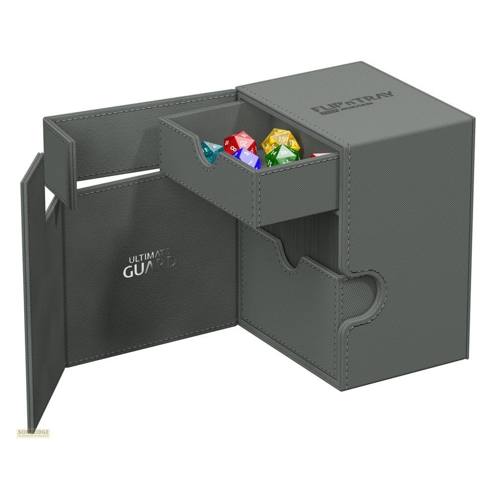 Boîte à dés grise Ultimate Guard Flip'n'Tray avec des compartiments ouverts contenant des dés colorés.