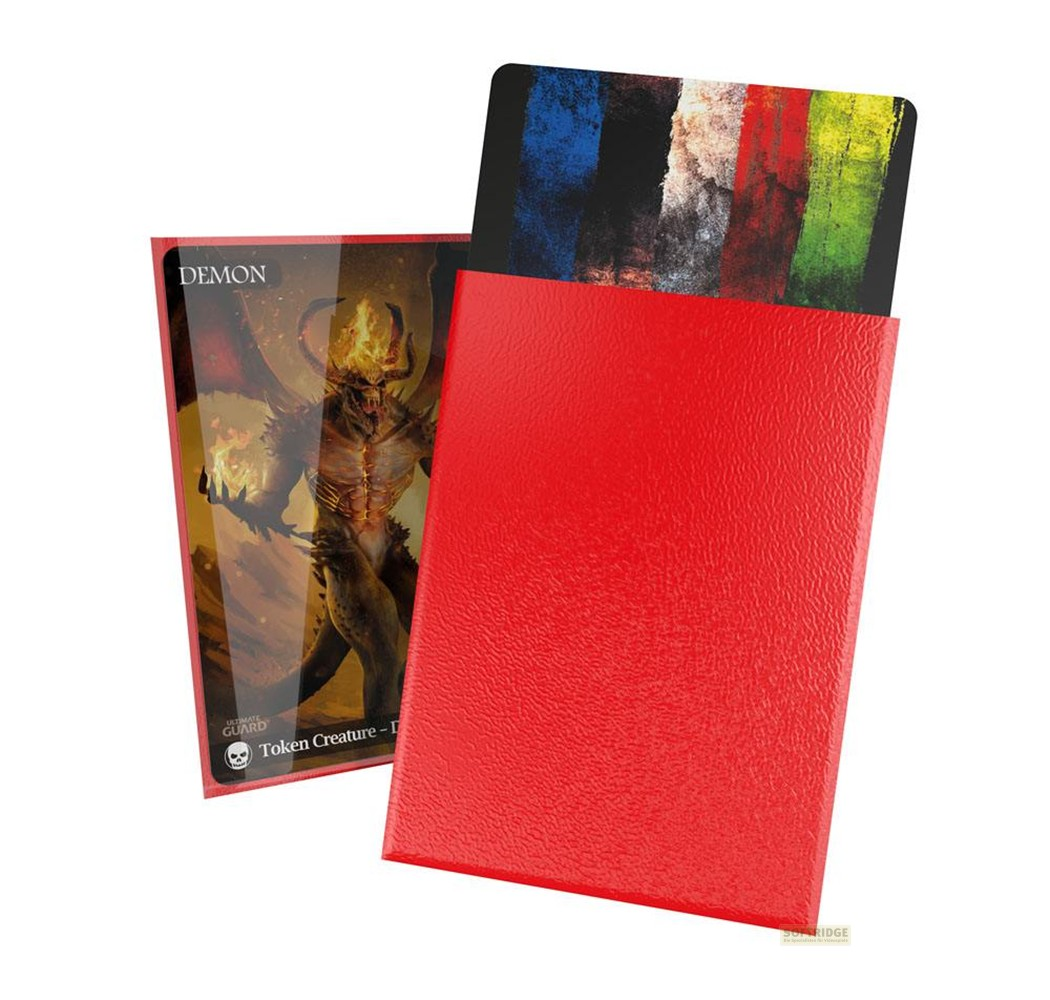 Une boîte de cartes rouge avec une carte de démon et une autre aux pinceaux colorés.