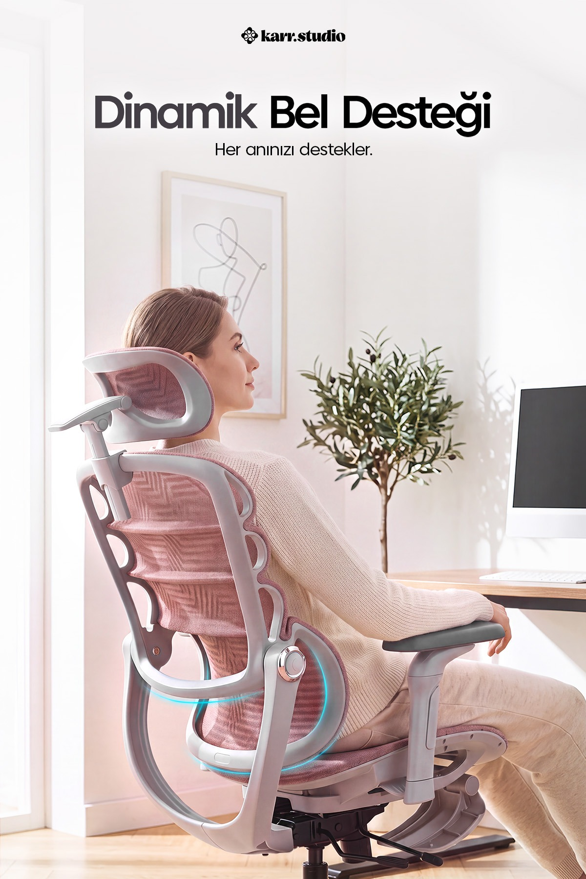 Bir kadın, bilgisayarlı bir masanın önünde modern pembe-gri ergonomik sandalyede oturuyor.