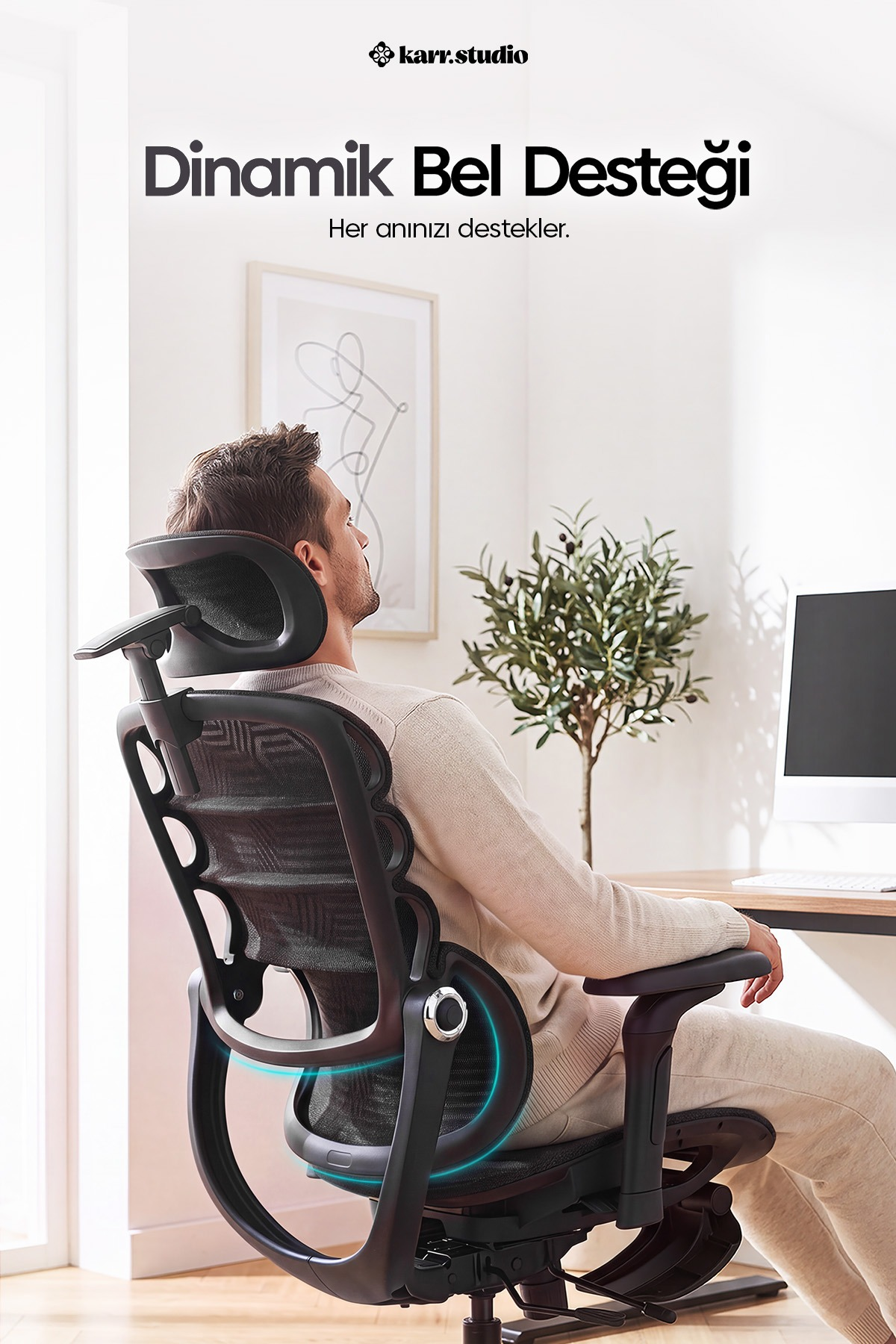 Bir adam, bir masada modern siyah ergonomik ofis sandalyesinde oturuyor.