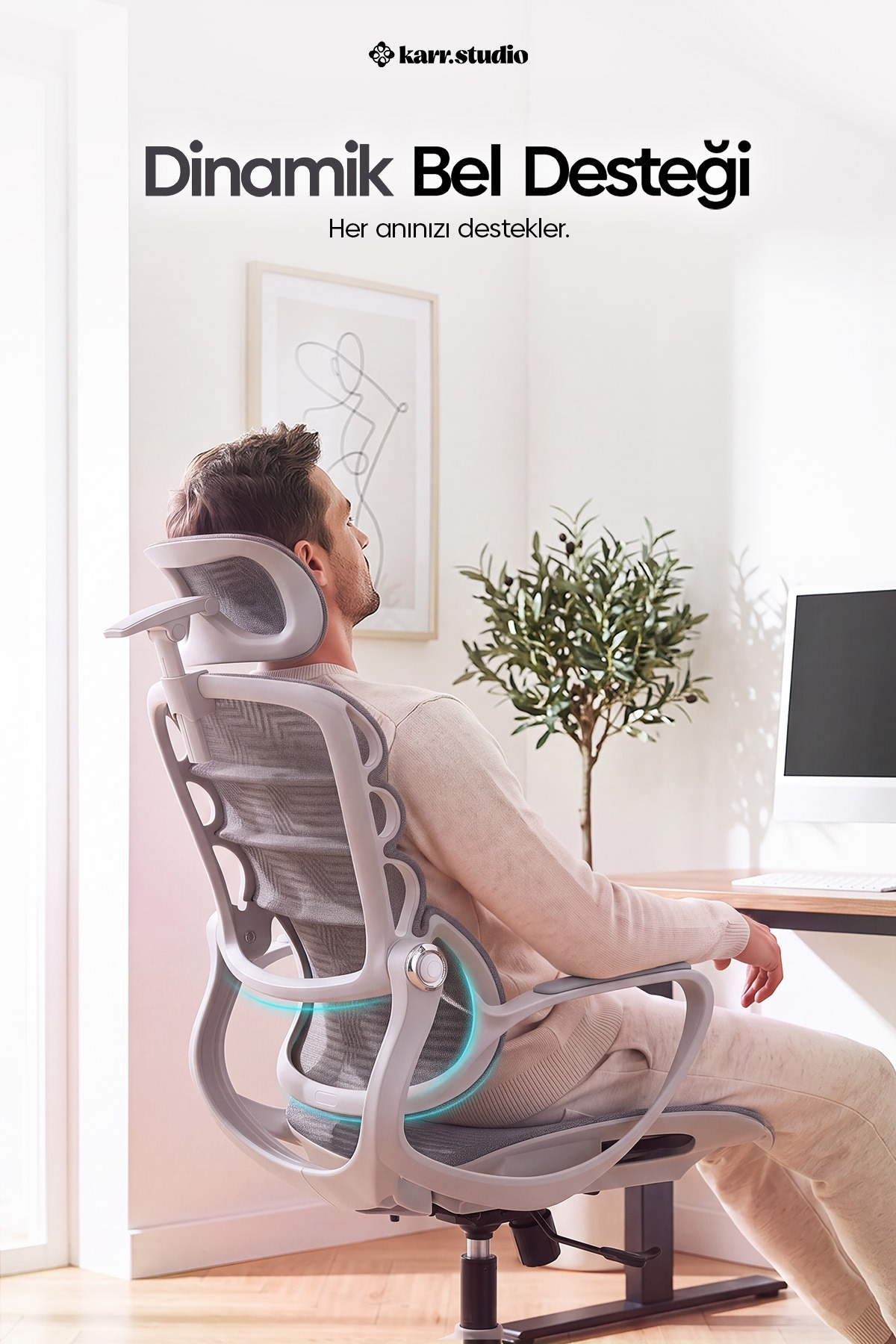 Bir adam bir masada ergonomik ofis sandalyesinde oturuyor.