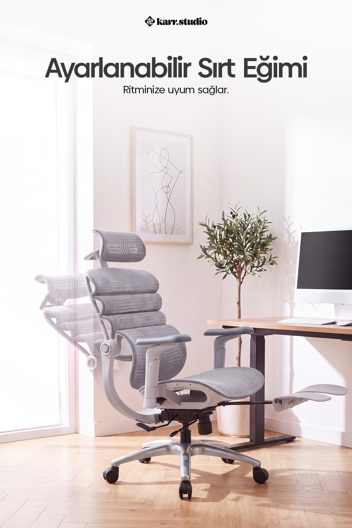 Aydınlık bir odada, ayarlanabilir sırt dayanağı, bitki ve çalışma masası olan gri ergonomik ofis koltuğu.