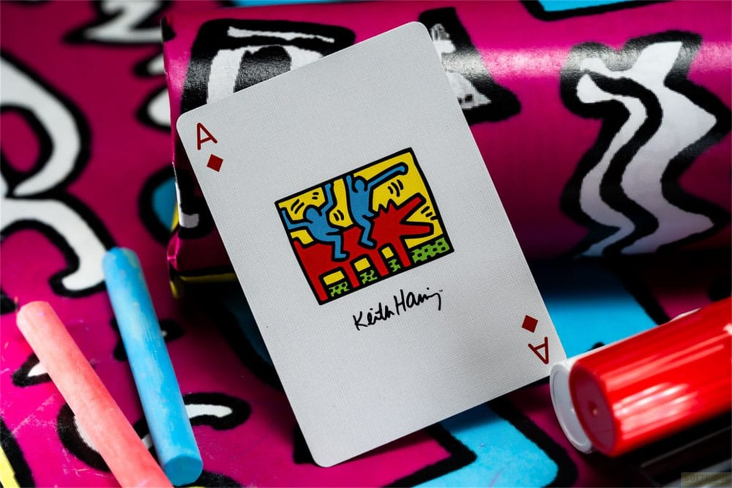 Une carte à jouer avec une œuvre de Keith Haring repose sur un fond coloré.