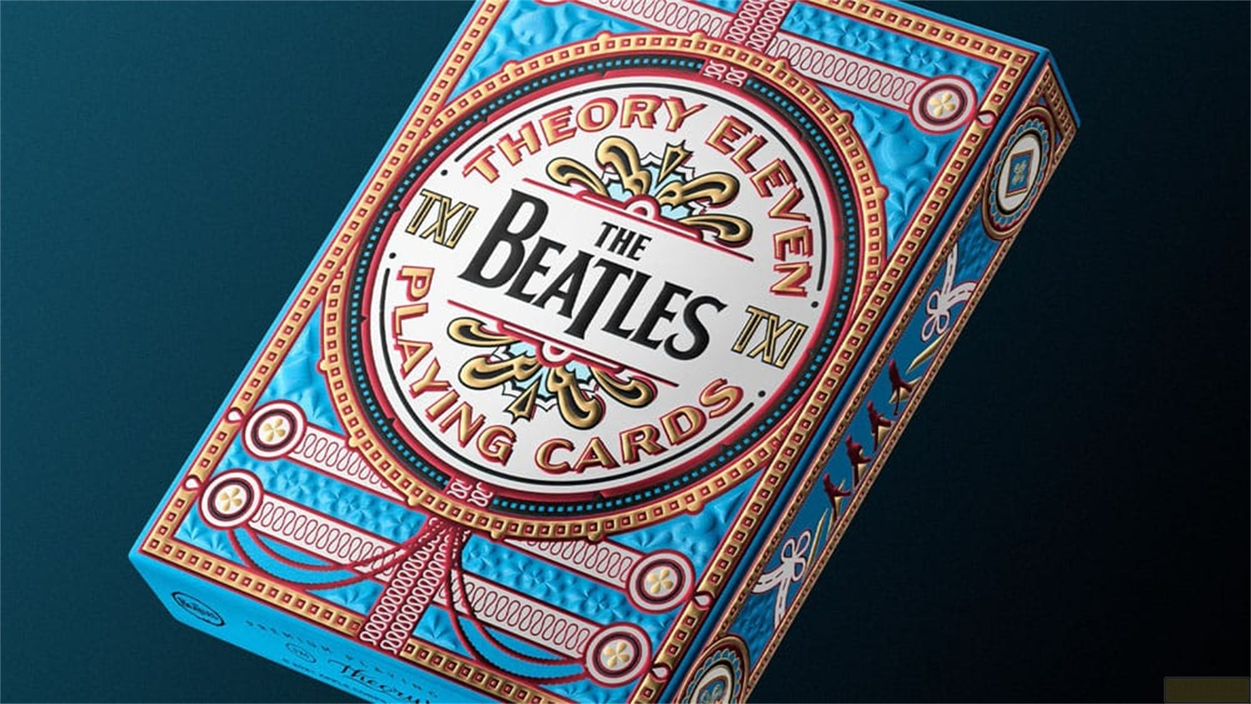Boîte de cartes à jouer The Beatles bleue complexe avec des détails dorés et rouges.