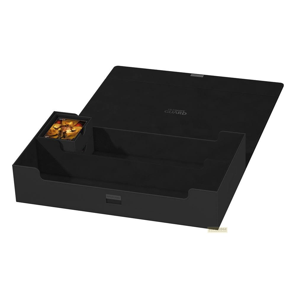 Une boîte de deck en similicuir noir est ouverte, montrant des compartiments et un jeu de cartes.