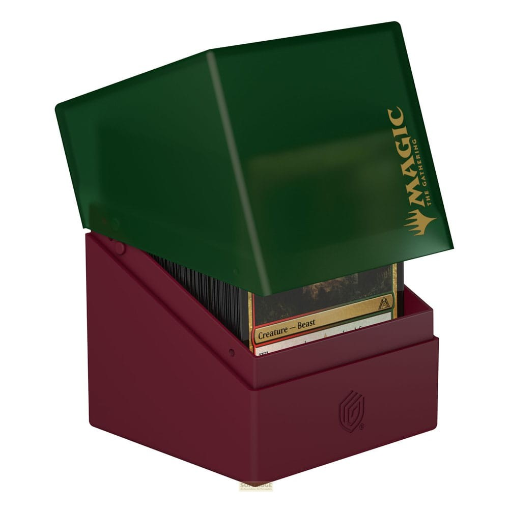 Une boîte de cartes rouge foncé avec un couvercle vert remplie de cartes Magic sur fond blanc.