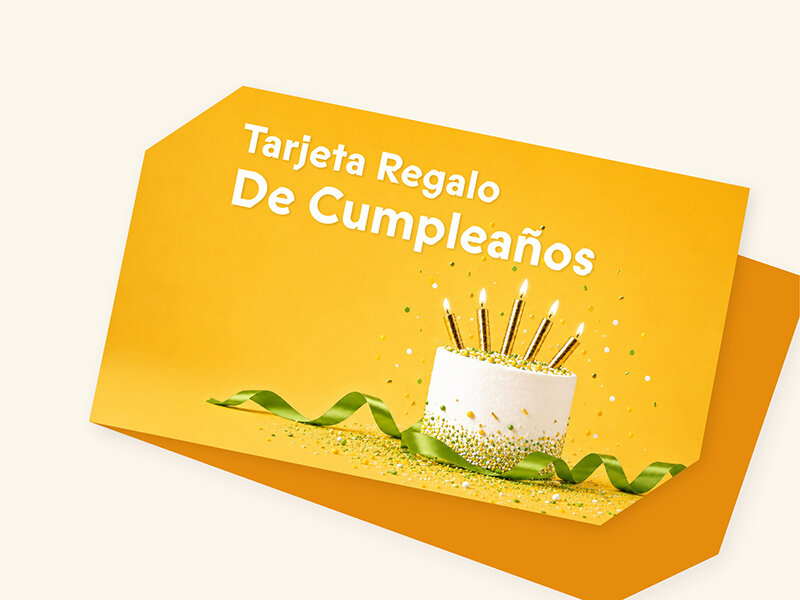 Tarjeta de cumpleaños amarilla con pastel blanco, velas encendidas, cinta verde y texto en español.
