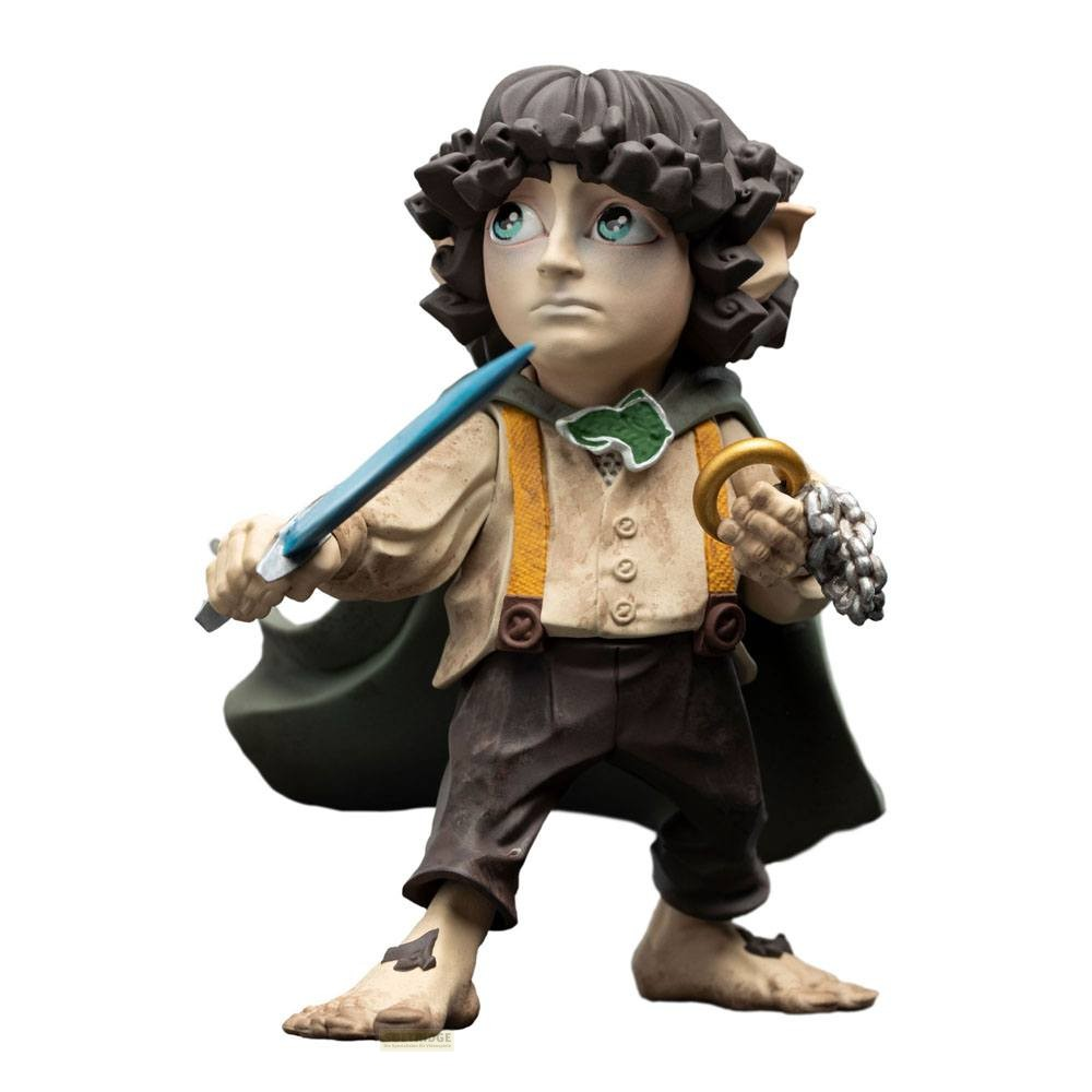 Una figura de vinilo de Frodo Bolsón con una espada azul y el Anillo Único en una cadena, usando una capa verde.