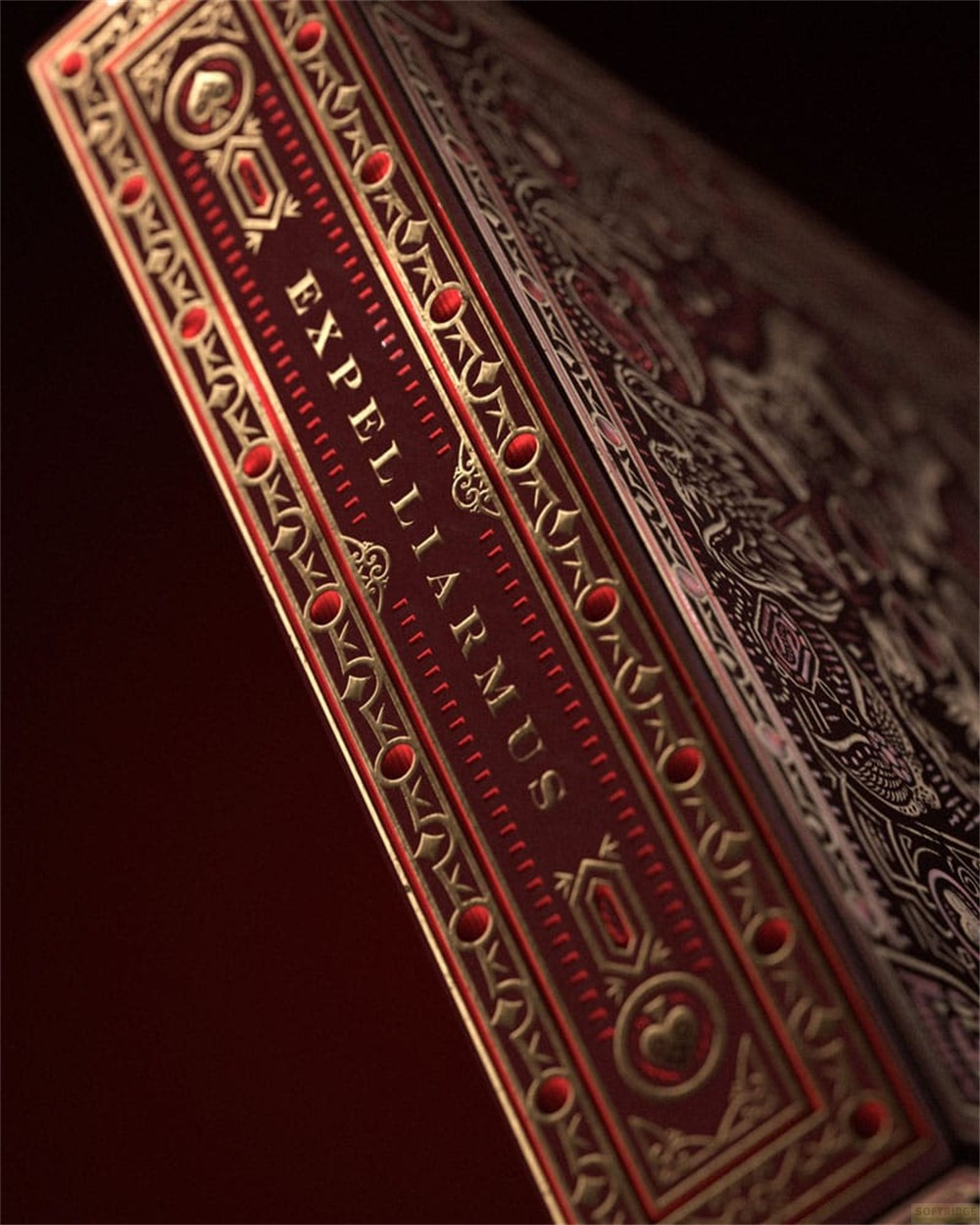 Une boîte de cartes rouge foncé avec des dorures et le texte EXPELLIARMUS.