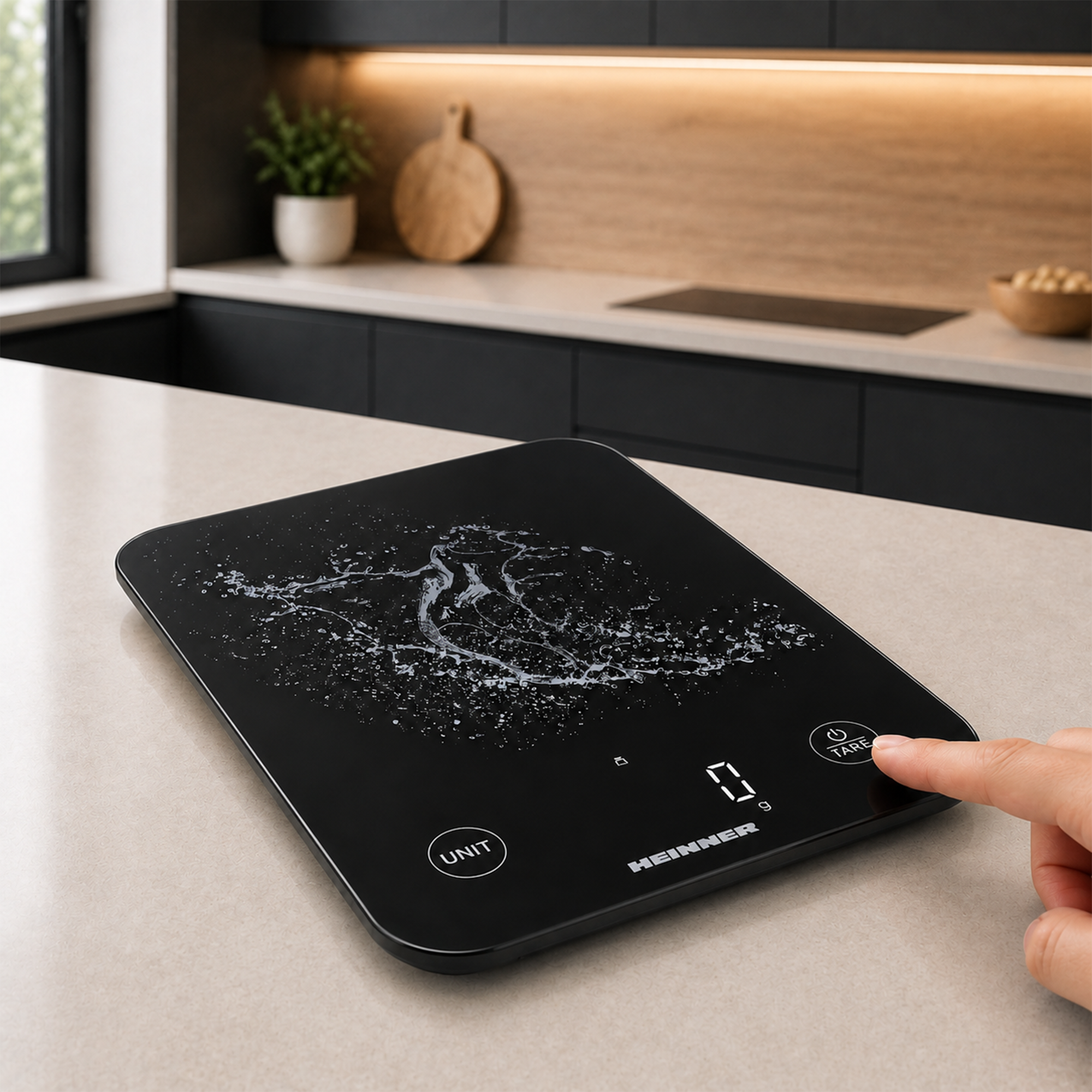 Ein Finger drückt den Ein-Aus-Knopf einer schwarzen digitalen Küchenwaage mit Wasserspritzer-Design in einer Küche.