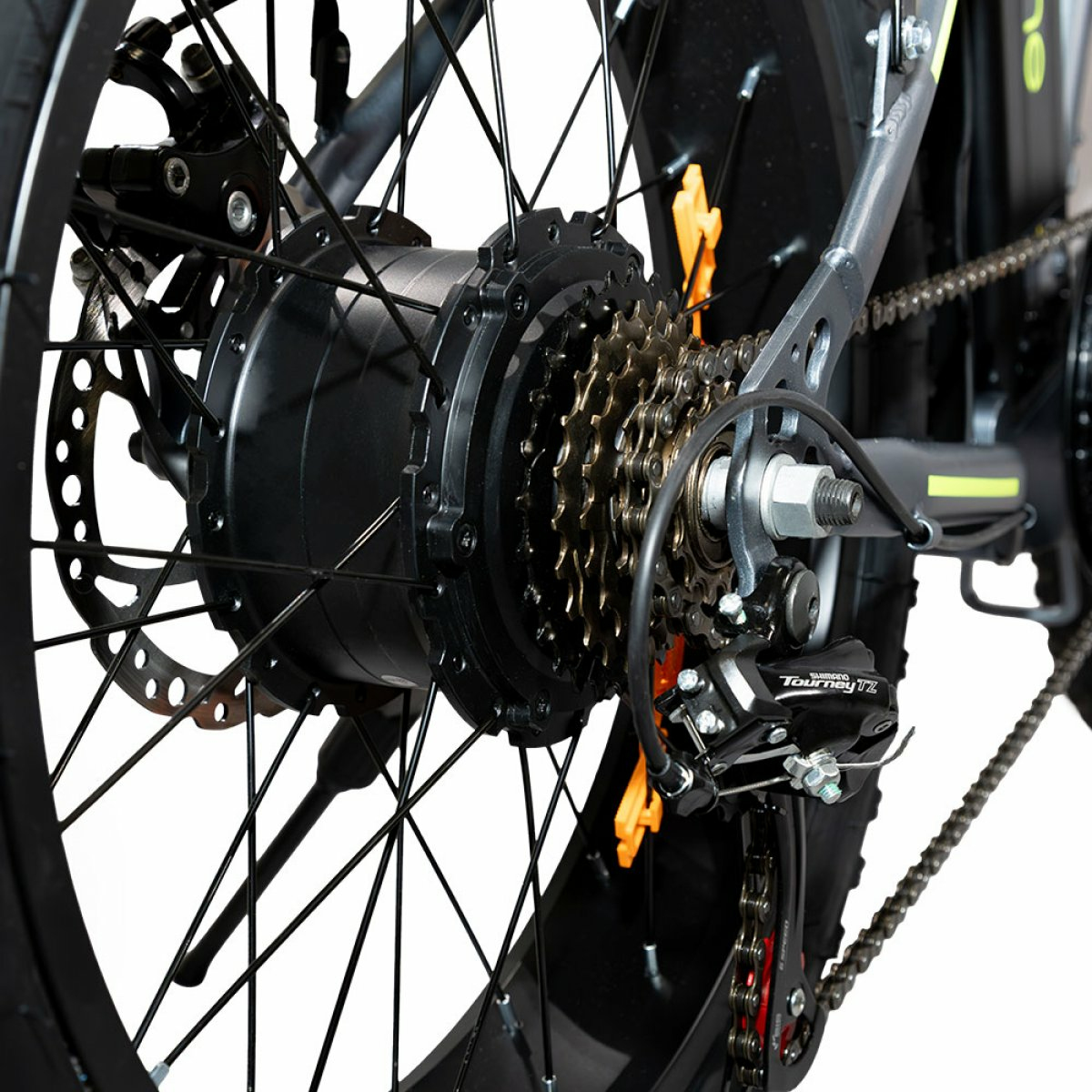 Primo piano della ruota posteriore di una e-bike con pignoni, catena e freno a disco.