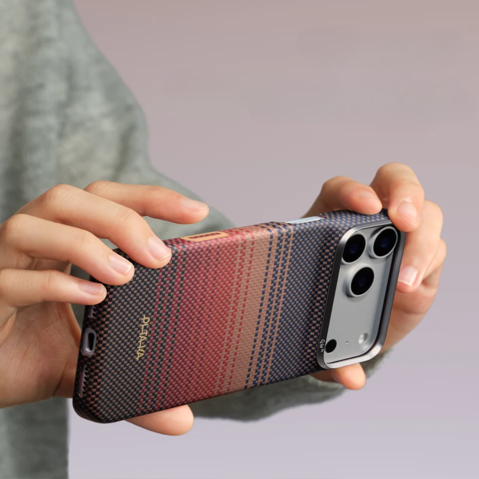 Osoba trzymająca smartfon w czerwono-niebieską kratkę z trzema obiektywami z tyłu.